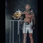 Le combattant UFC Jean Silva qui regarde la ceinture de champion UFC
