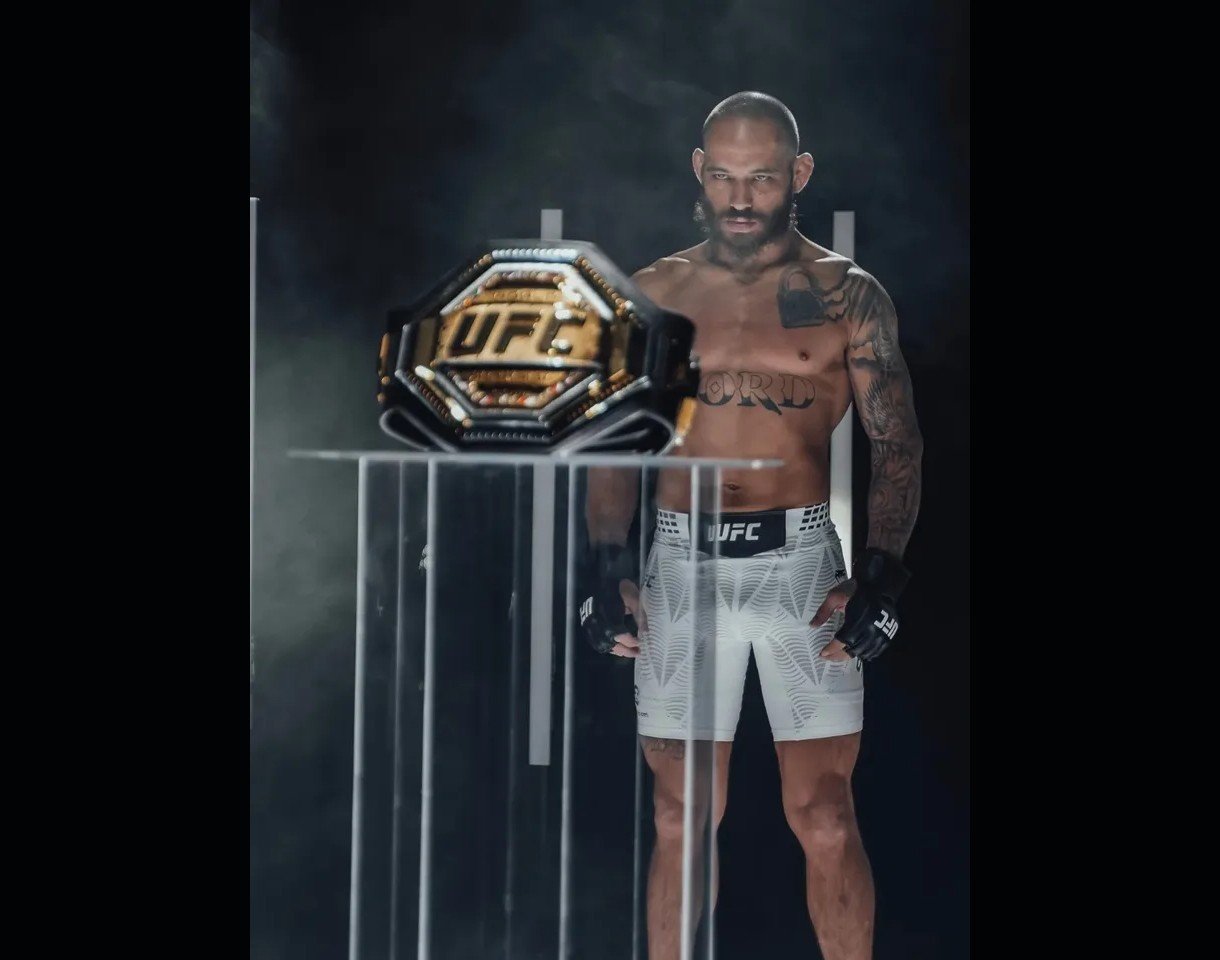 Le combattant UFC Jean Silva qui regarde la ceinture de champion UFC