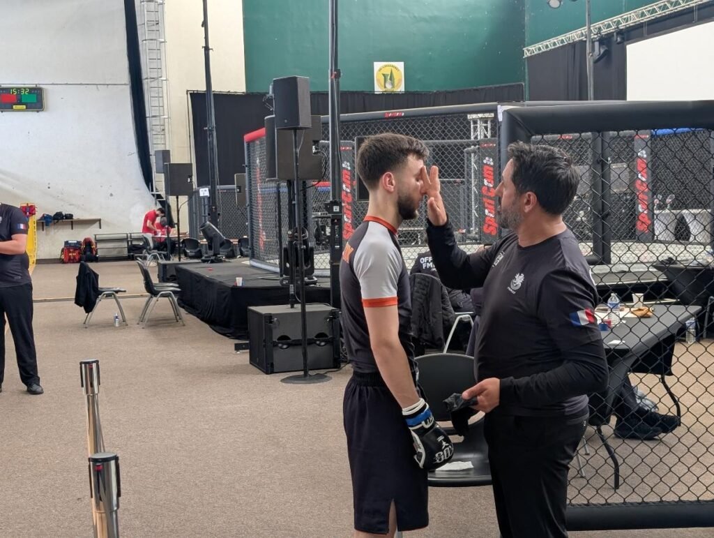 l'entraineur passe de la vaseline sur le visage du combattant avant d'entrer dans la cage de MMA